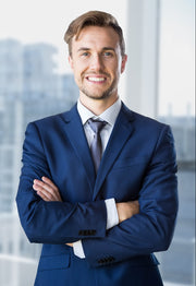 Man in a blue suit standing in an office with cityscape background